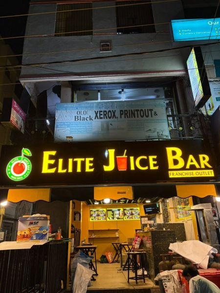 Illuminated commercial signage visible at night, Chennai